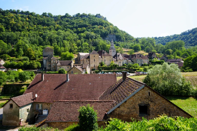 Le village de Baume-les-Messieurs au pied des falaises boisées de la reculée